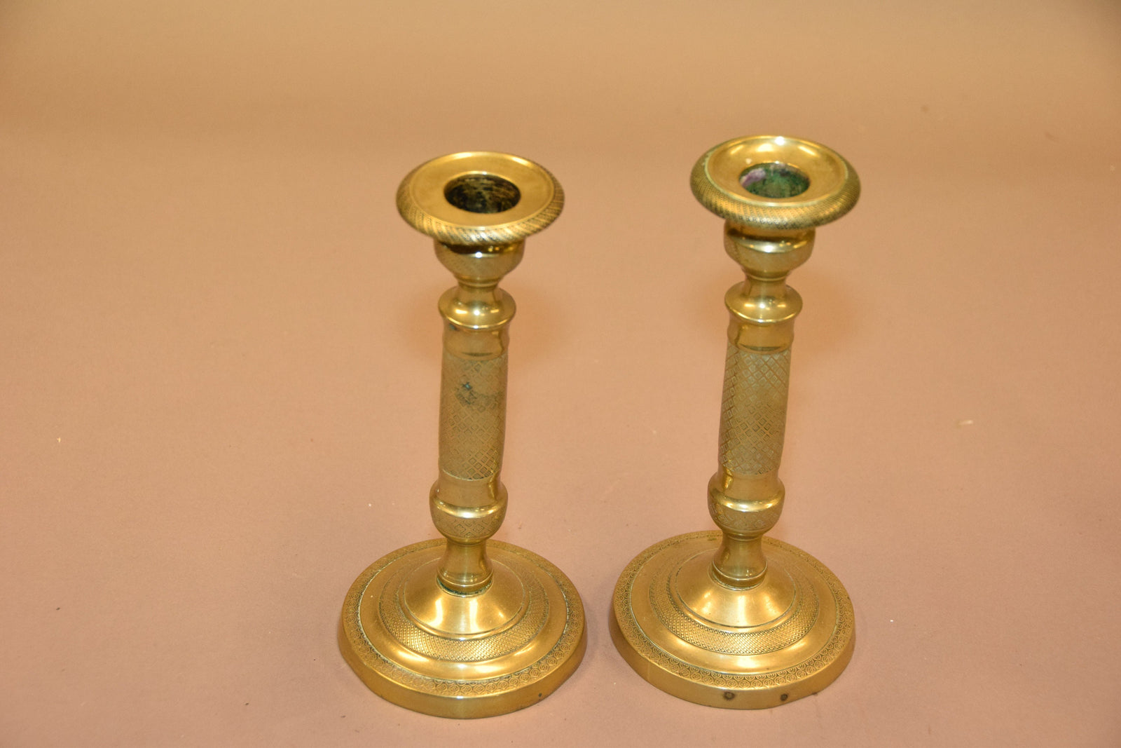 Pair of antique bronze candlesticks with intricate detailing, crisscross diamond texture, and a rich aged patina. Elegant and timeless, these vintage candle holders are perfect for dining tables, mantels, or decorative displays. Crafted with sturdy bronze construction, they add sophistication to any space. A must-have for antique collectors and lovers of classic home decor.