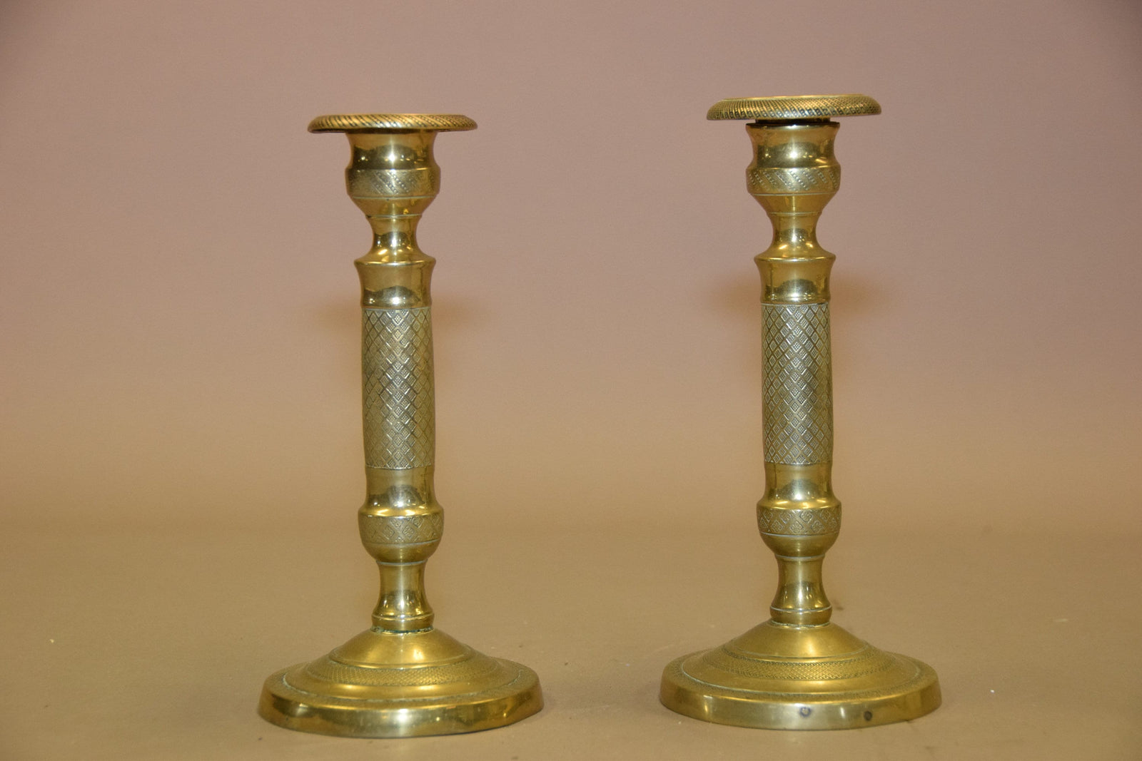 Pair of antique bronze candlesticks with intricate detailing, crisscross diamond texture, and a rich aged patina. Elegant and timeless, these vintage candle holders are perfect for dining tables, mantels, or decorative displays. Crafted with sturdy bronze construction, they add sophistication to any space. A must-have for antique collectors and lovers of classic home decor.