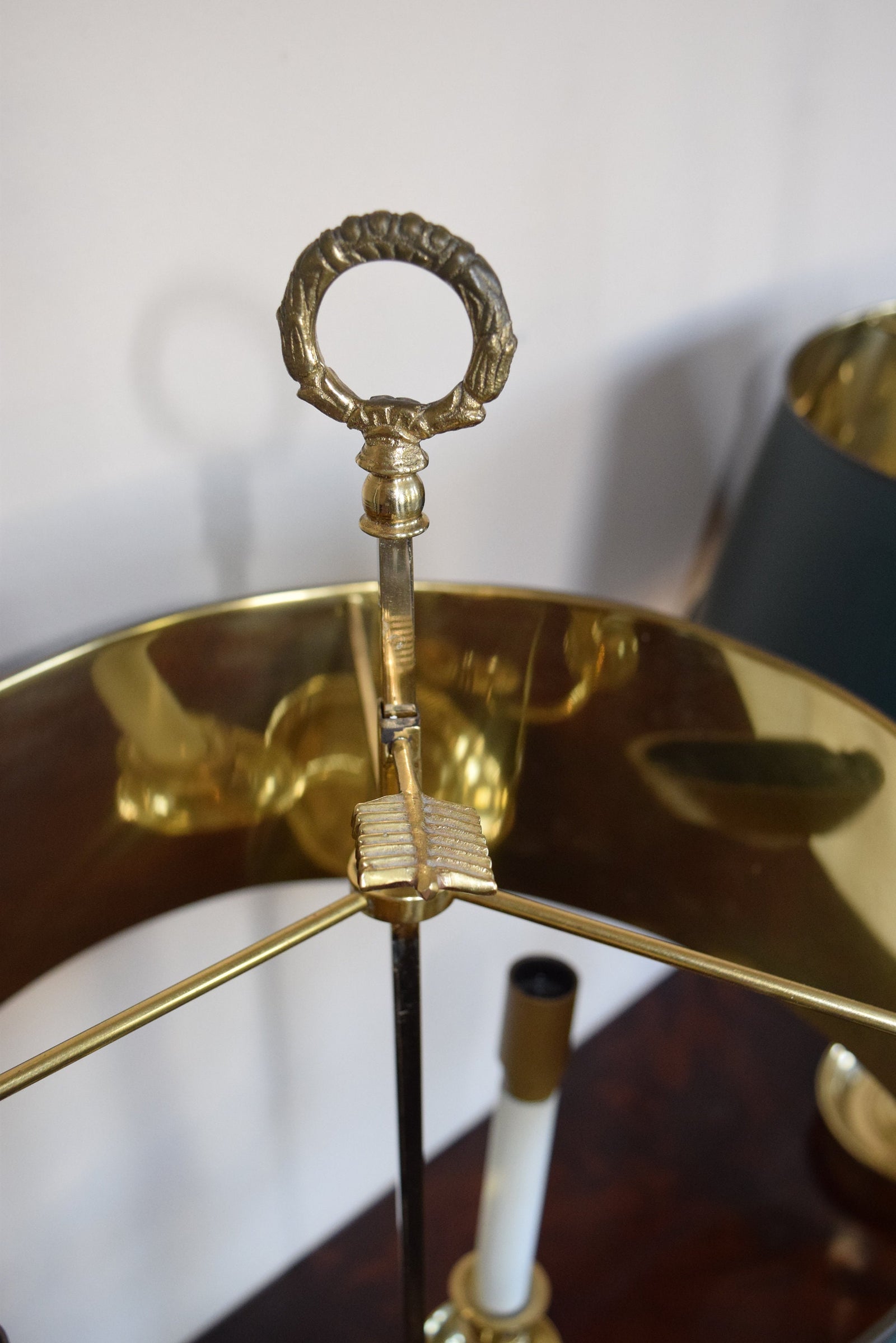 A pair of French Empire-style Bouillotte lamps with solid brass bases and deep green tole metal shades. Each lamp features three gracefully curved arms in a classic candelabra silhouette, exuding vintage sophistication. The adjustable shades allow for controlled lighting, perfect for desks, side tables, or elegant home decor. Ideal for lovers of antique lighting, French neoclassical design, and timeless statement pieces.