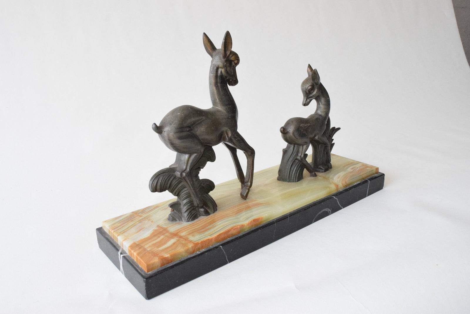Art Deco deer sculpture featuring two elegant deer standing on a solid marble base. This vintage 1920s zalmac figurine captures the sleek, geometric aesthetic of the Art Deco era. A perfect collectible for art lovers, home decorators, or vintage enthusiasts, this sculpture enhances any space with its timeless elegance and sophisticated design. Ideal for display in homes, offices, or galleries.