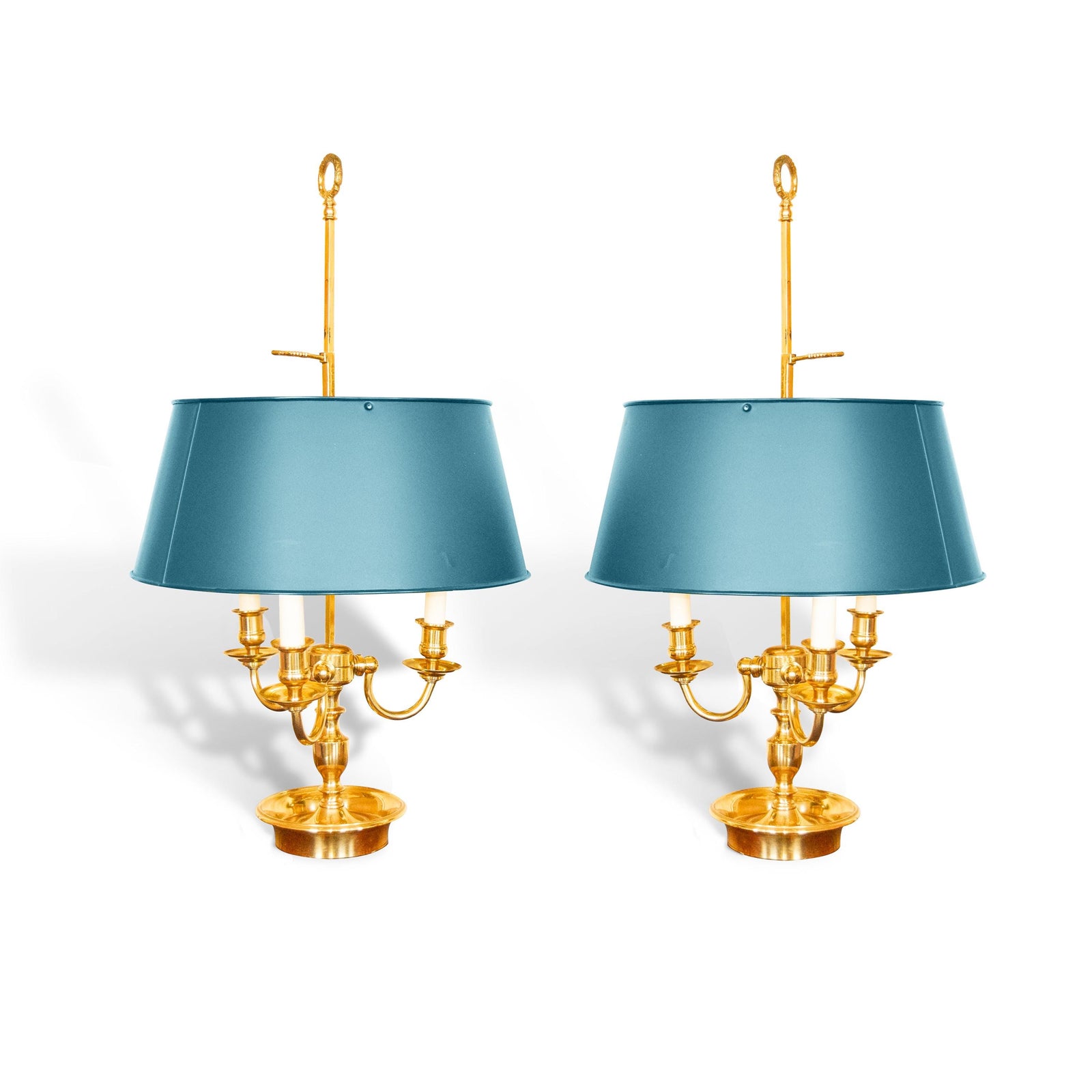 A pair of French Empire-style Bouillotte lamps with solid brass bases and deep green tole metal shades. Each lamp features three gracefully curved arms in a classic candelabra silhouette, exuding vintage sophistication. The adjustable shades allow for controlled lighting, perfect for desks, side tables, or elegant home decor. Ideal for lovers of antique lighting, French neoclassical design, and timeless statement pieces.