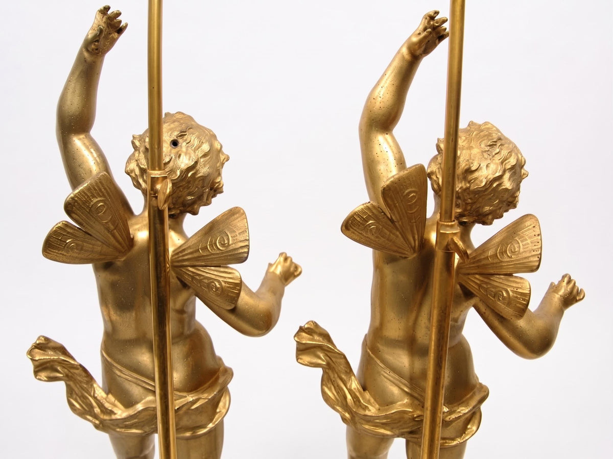 Pair of French Gilt Putti Table Lamps, Winged Cherub Figures on White Marble Bases — France, Early 20th Century