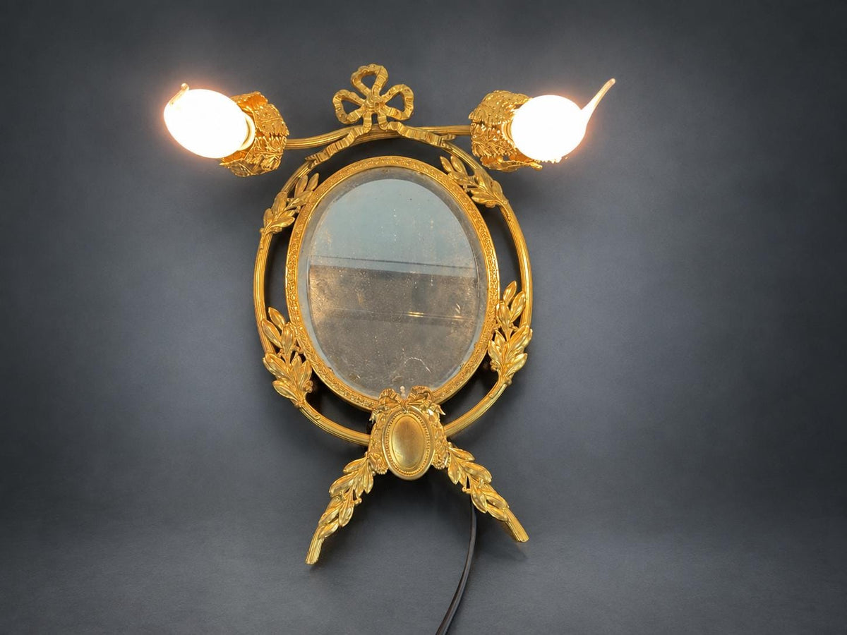 Louis XVI Style Mirrored Wall Sconce, Gilt Metal Girandole with Bevelled Oval Mirror, Ribbon Bow and Laurel, Two Lights