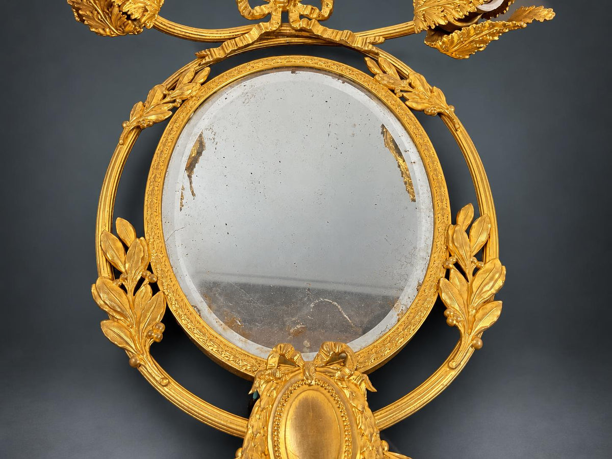 Louis XVI Style Mirrored Wall Sconce, Gilt Metal Girandole with Bevelled Oval Mirror, Ribbon Bow and Laurel, Two Lights