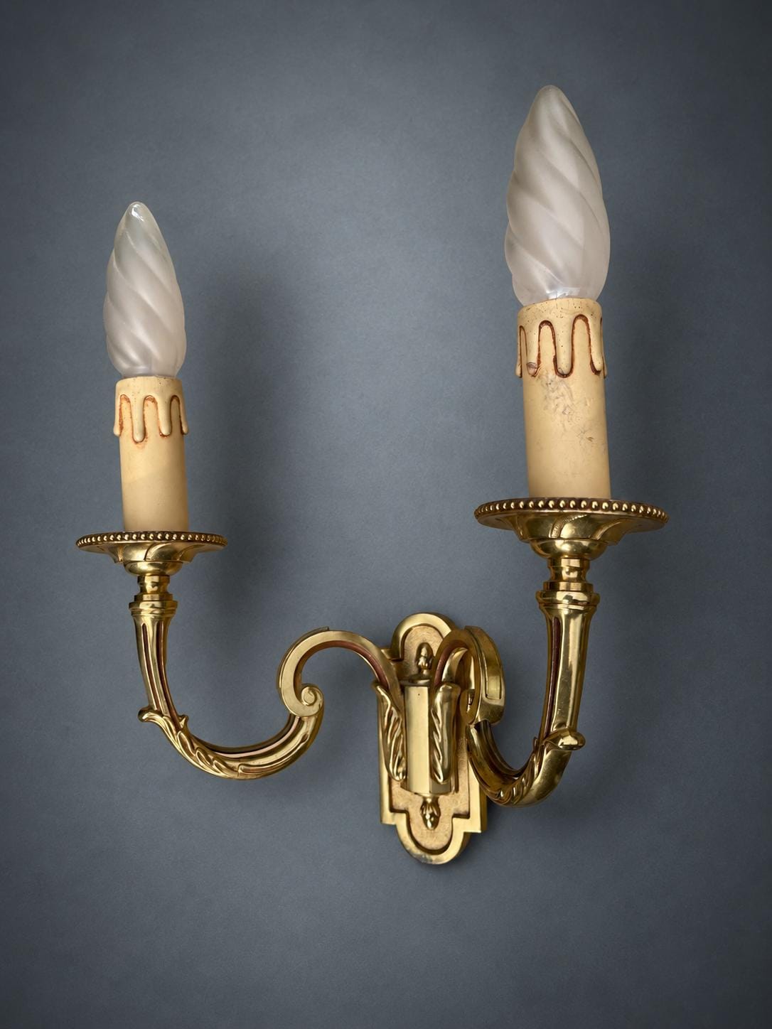 Pair of Gilt Metal Two-Arm Wall Sconces with Candle-Form Covers and Scrolled Arms