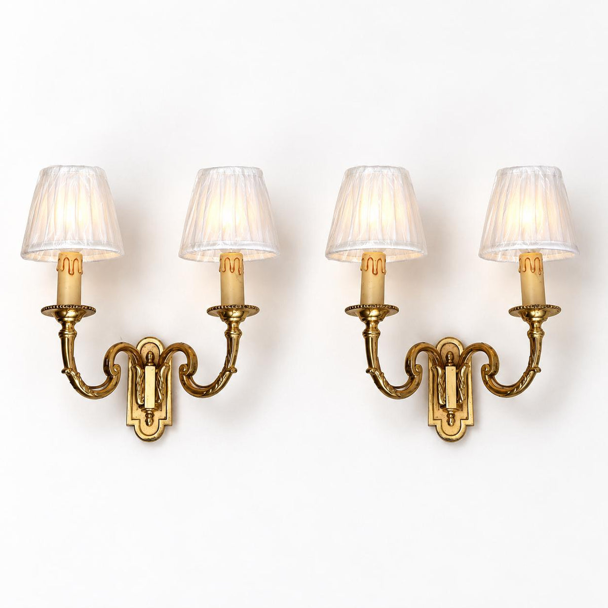 Pair of Gilt Metal Two-Arm Wall Sconces with Candle-Form Covers and Scrolled Arms