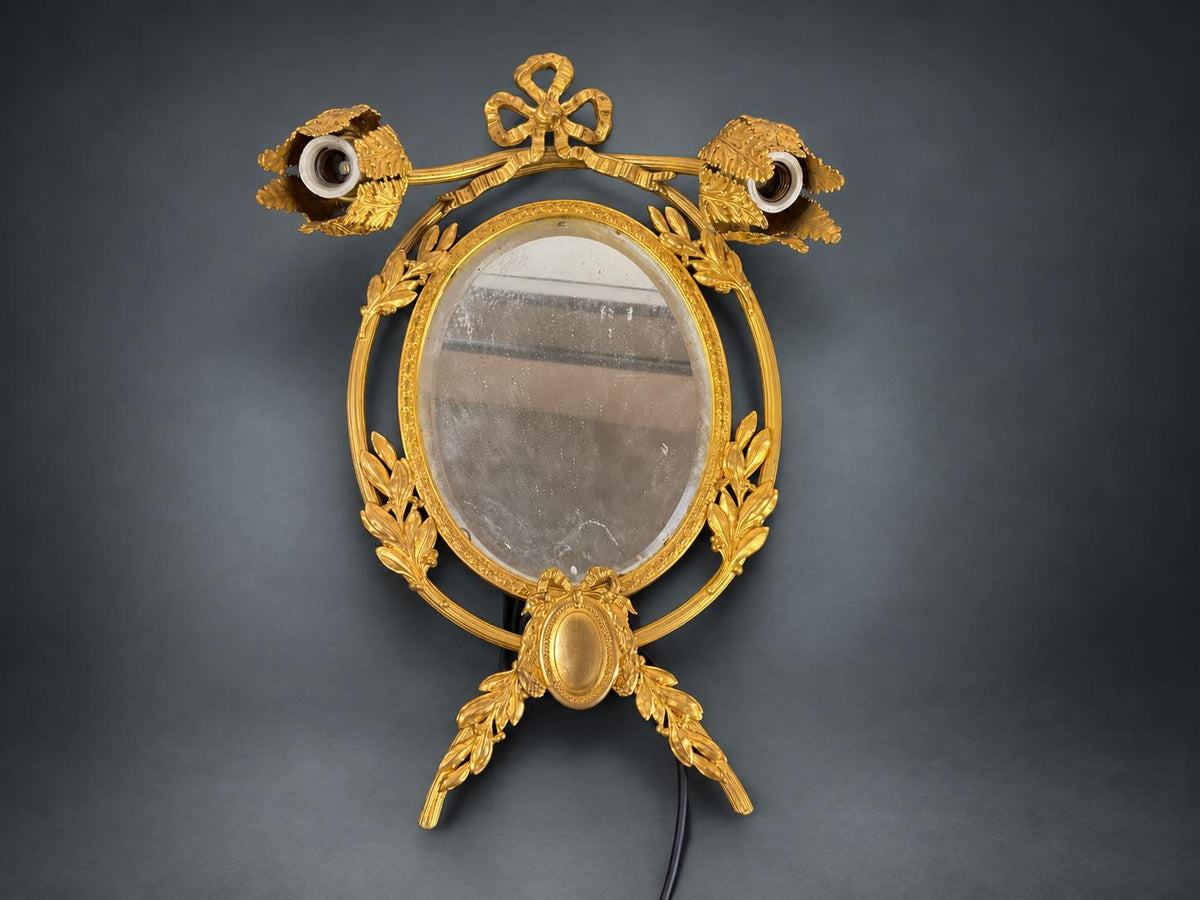 Louis XVI Style Mirrored Wall Sconce, Gilt Metal Girandole with Bevelled Oval Mirror, Ribbon Bow and Laurel, Two Lights