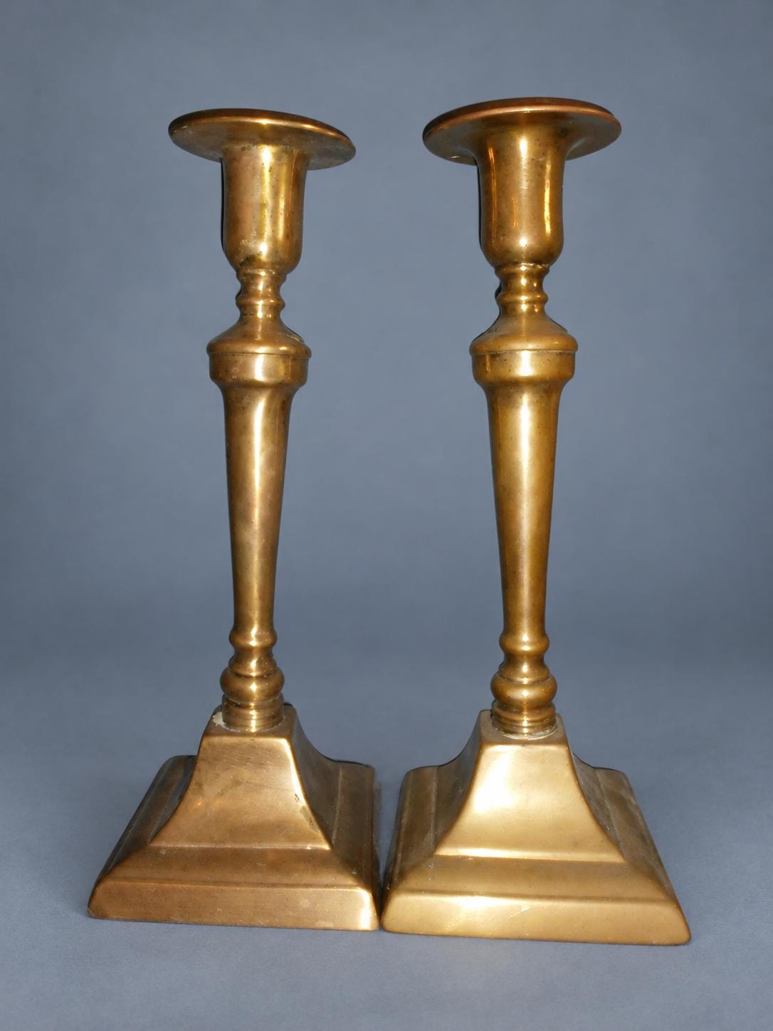 Vintage Pair of Neoclassical Style Candlesticks, Brass-Tone Metal with Tapered Baluster Stems and Stepped Square Bases, 19th Century, 24 cm