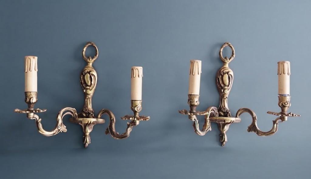Pair of Vintage 1970s Bronze Louis XV Style Wall Sconces, Two-Arm Design with Laurel Ring Crest and Cartouche Backplate, Candle Lights