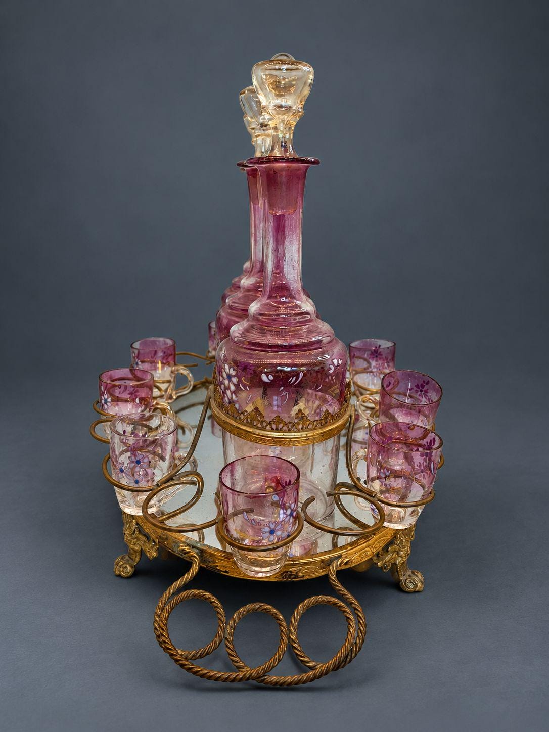 Antique Napoleon III Liqueur Set, Two Cranberry Enameled Glass Decanters and Cordial Glasses on Gilt Brass Mirrored Tray Stand