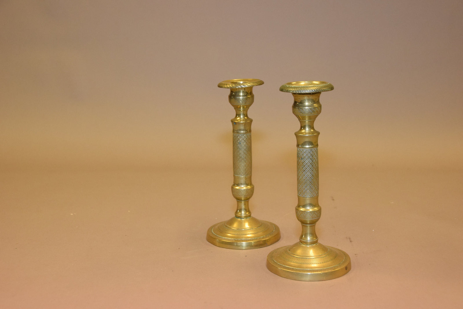 Pair of antique bronze candlesticks with intricate detailing, crisscross diamond texture, and a rich aged patina. Elegant and timeless, these vintage candle holders are perfect for dining tables, mantels, or decorative displays. Crafted with sturdy bronze construction, they add sophistication to any space. A must-have for antique collectors and lovers of classic home decor.