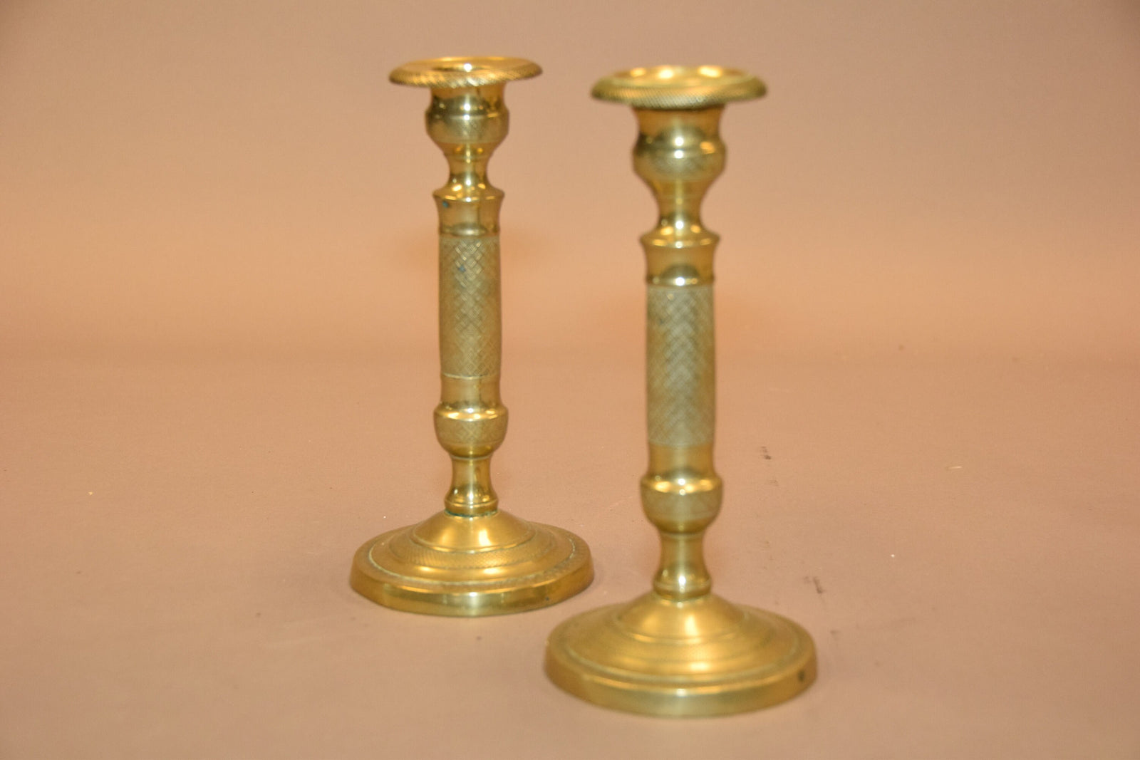 Pair of antique bronze candlesticks with intricate detailing, crisscross diamond texture, and a rich aged patina. Elegant and timeless, these vintage candle holders are perfect for dining tables, mantels, or decorative displays. Crafted with sturdy bronze construction, they add sophistication to any space. A must-have for antique collectors and lovers of classic home decor.