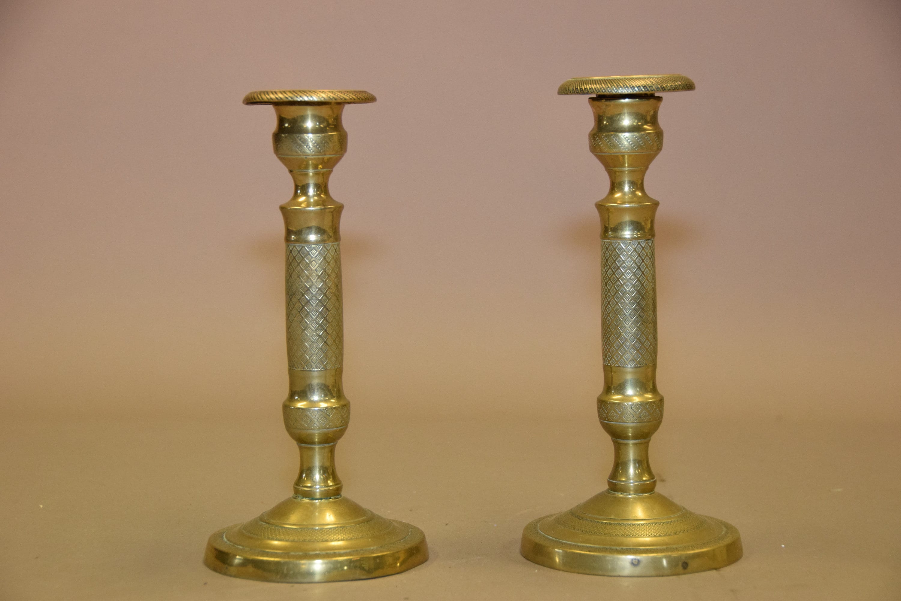 Pair of antique bronze candlesticks with intricate detailing, crisscross diamond texture, and a rich aged patina. Elegant and timeless, these vintage candle holders are perfect for dining tables, mantels, or decorative displays. Crafted with sturdy bronze construction, they add sophistication to any space. A must-have for antique collectors and lovers of classic home decor.