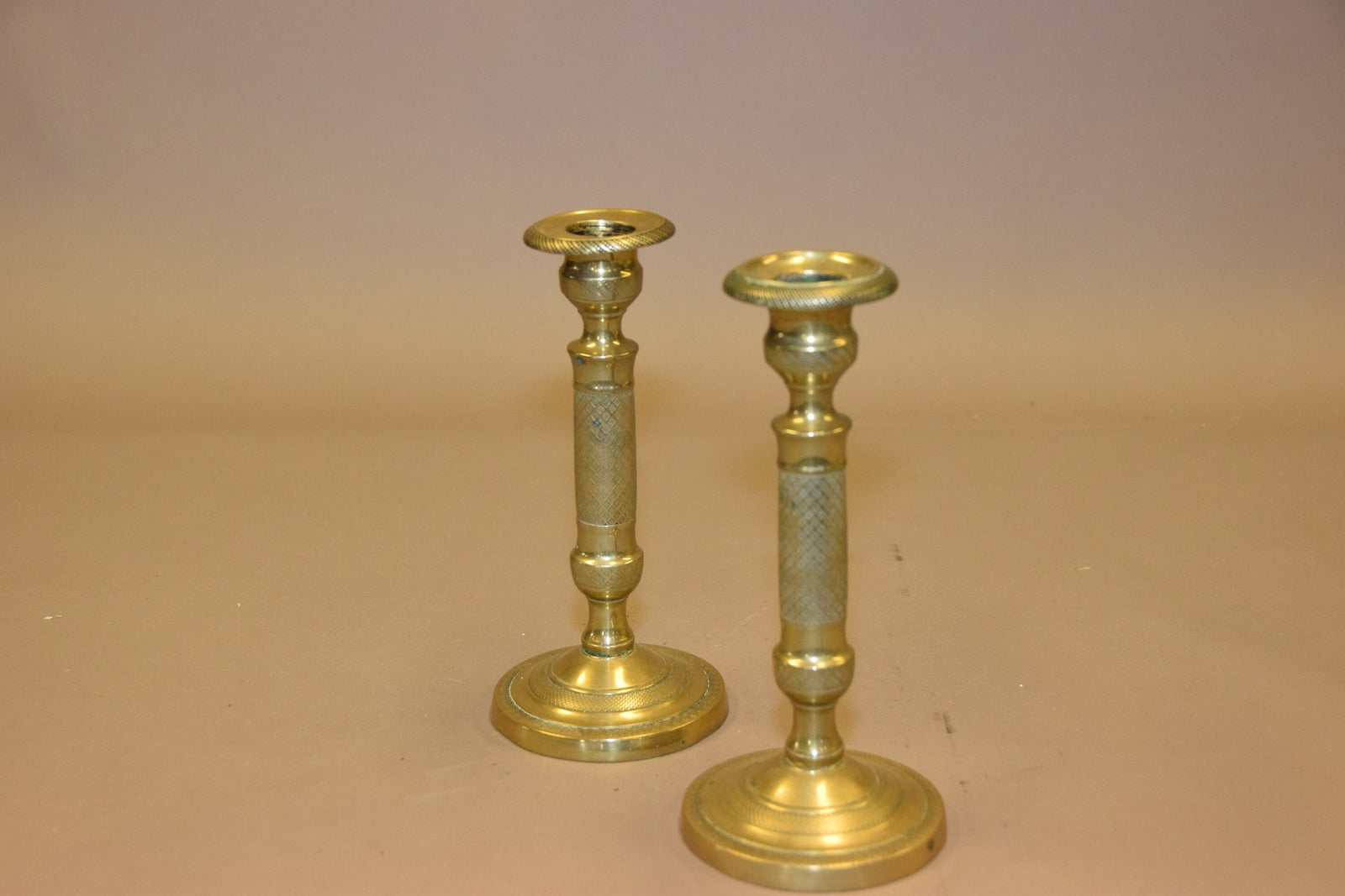 Pair of antique bronze candlesticks with intricate detailing, crisscross diamond texture, and a rich aged patina. Elegant and timeless, these vintage candle holders are perfect for dining tables, mantels, or decorative displays. Crafted with sturdy bronze construction, they add sophistication to any space. A must-have for antique collectors and lovers of classic home decor.