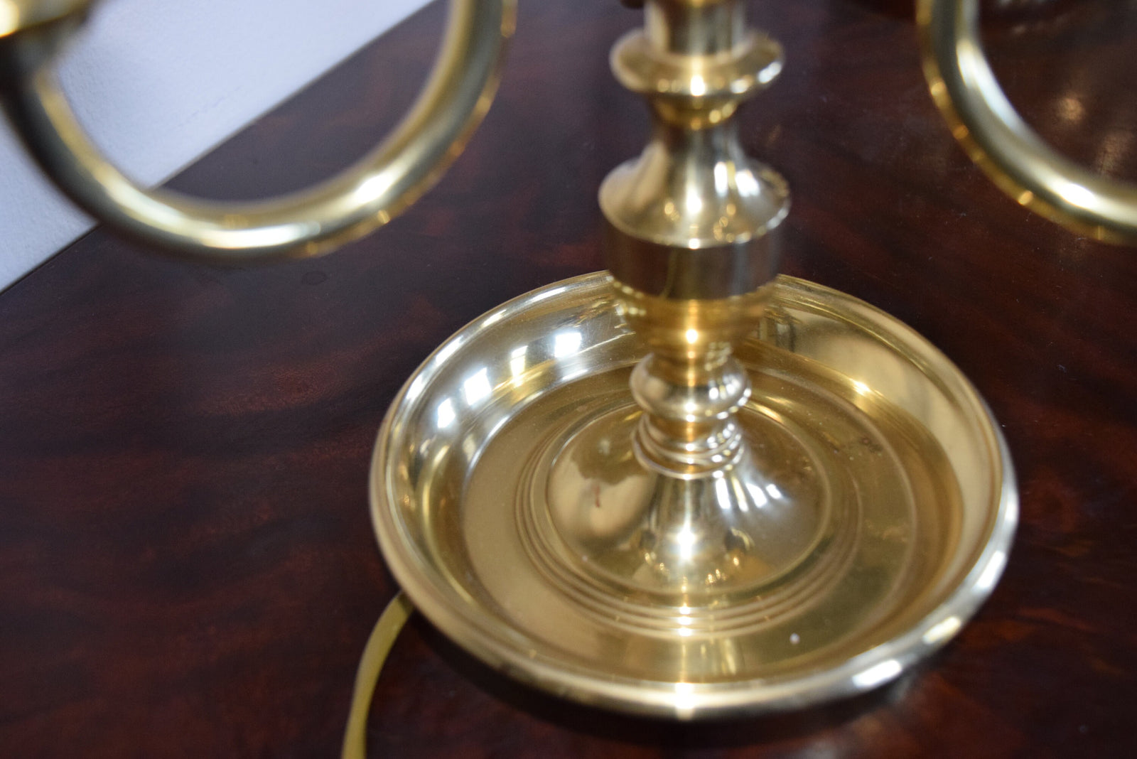 A pair of French Empire-style Bouillotte lamps with solid brass bases and deep green tole metal shades. Each lamp features three gracefully curved arms in a classic candelabra silhouette, exuding vintage sophistication. The adjustable shades allow for controlled lighting, perfect for desks, side tables, or elegant home decor. Ideal for lovers of antique lighting, French neoclassical design, and timeless statement pieces.