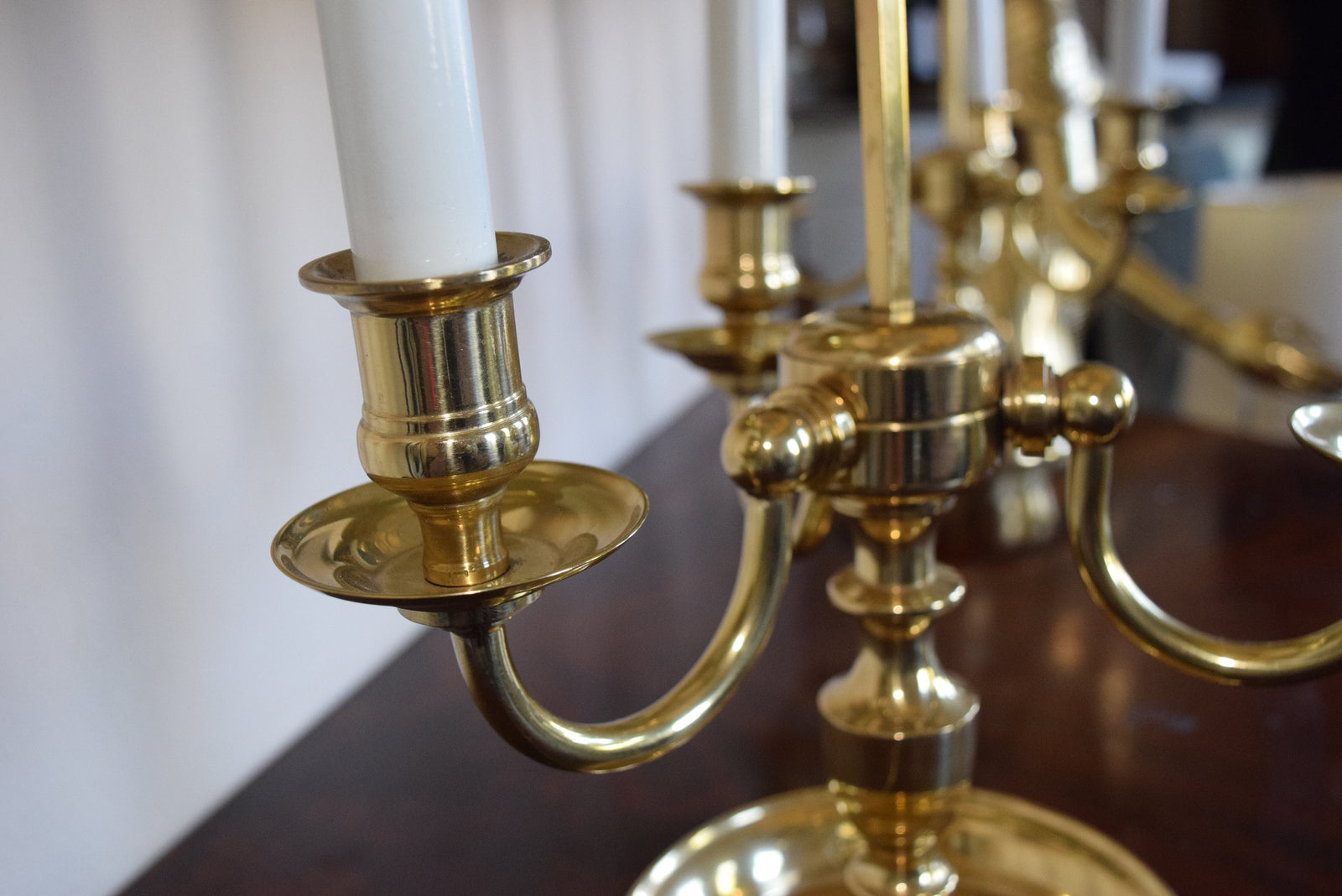 A pair of French Empire-style Bouillotte lamps with solid brass bases and deep green tole metal shades. Each lamp features three gracefully curved arms in a classic candelabra silhouette, exuding vintage sophistication. The adjustable shades allow for controlled lighting, perfect for desks, side tables, or elegant home decor. Ideal for lovers of antique lighting, French neoclassical design, and timeless statement pieces.