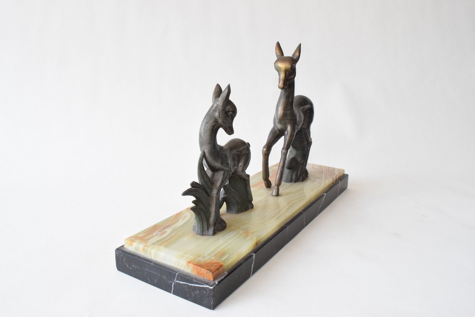 Art Deco deer sculpture featuring two elegant deer standing on a solid marble base. This vintage 1920s zalmac figurine captures the sleek, geometric aesthetic of the Art Deco era. A perfect collectible for art lovers, home decorators, or vintage enthusiasts, this sculpture enhances any space with its timeless elegance and sophisticated design. Ideal for display in homes, offices, or galleries.