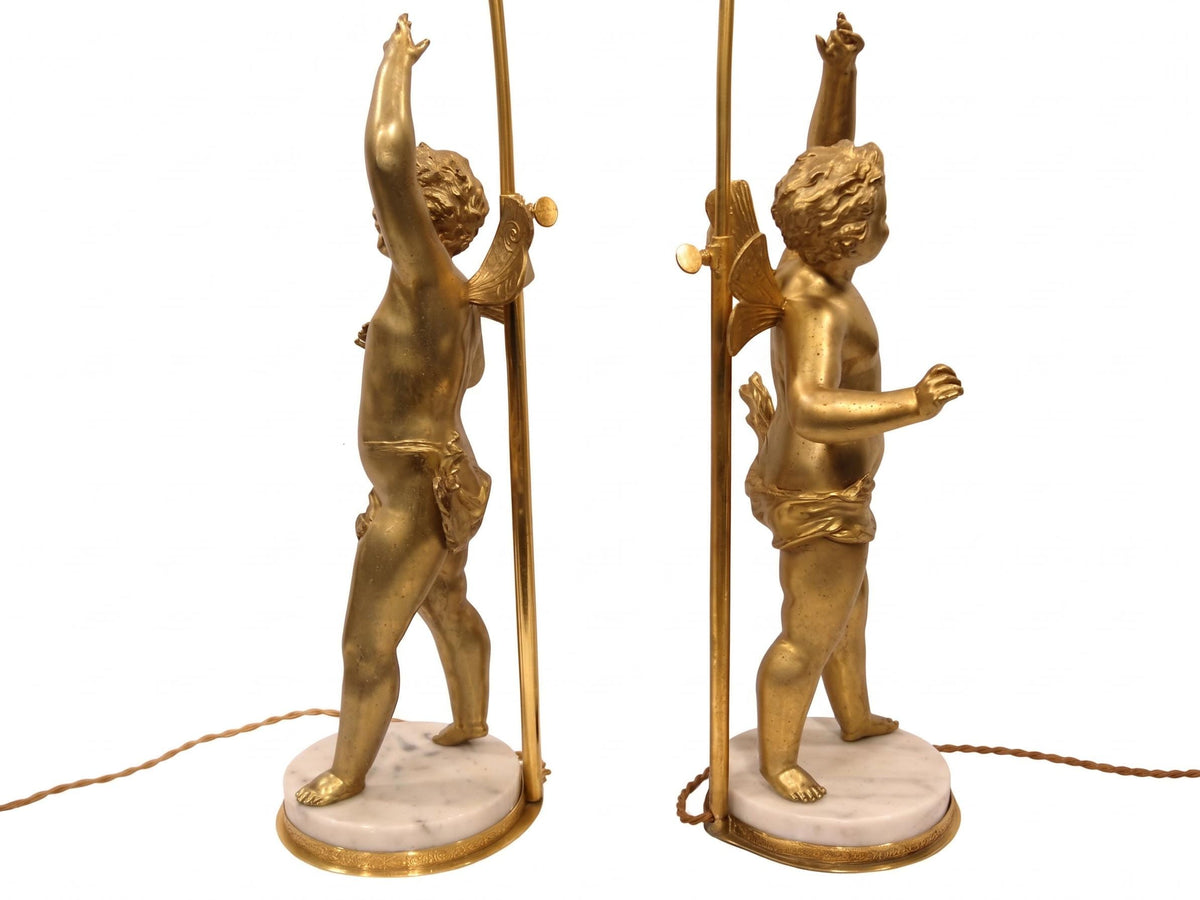 Pair of French Gilt Putti Table Lamps, Winged Cherub Figures on White Marble Bases — France, Early 20th Century