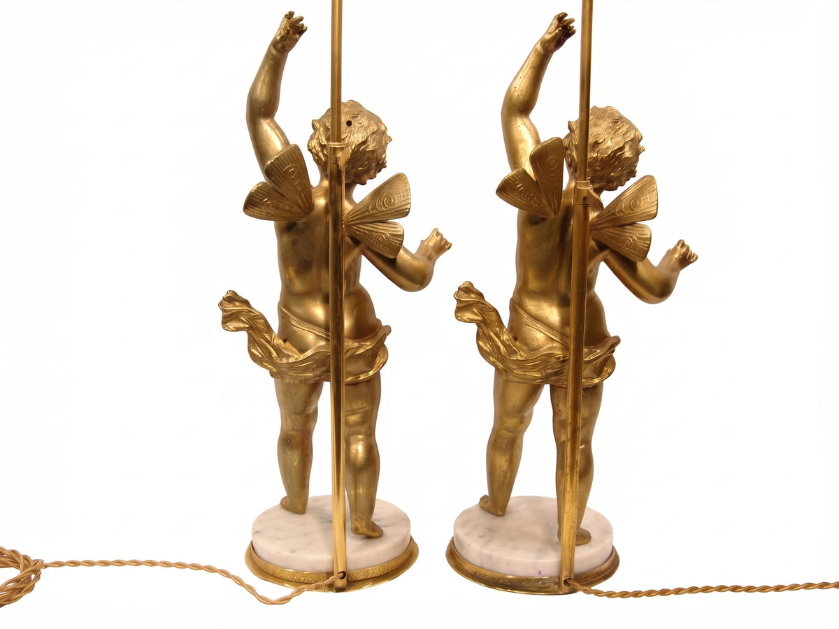 Pair of French Gilt Putti Table Lamps, Winged Cherub Figures on White Marble Bases — France, Early 20th Century