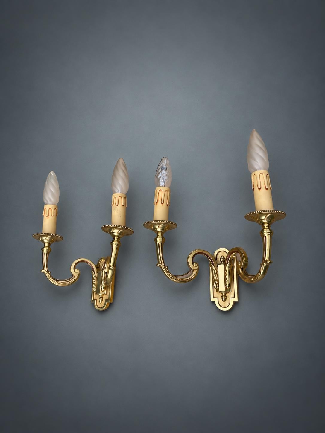 Pair of Gilt Metal Two-Arm Wall Sconces with Candle-Form Covers and Scrolled Arms