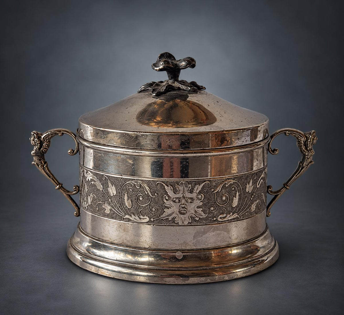 Lidded Bonbonnière in Silver-Tone Metal, Embossed Mask and Scroll Band, Figural Handles, Leaf Finial, Renaissance Revival Style