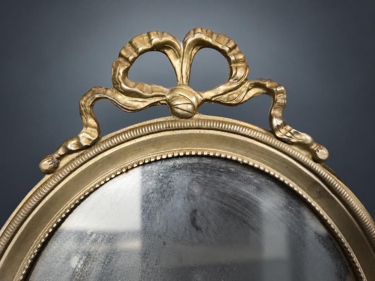 Small Oval Louis XVI Style Wall Mirror, Gilt Metal Frame with Ribbon-Bow Crest and Beaded Borders