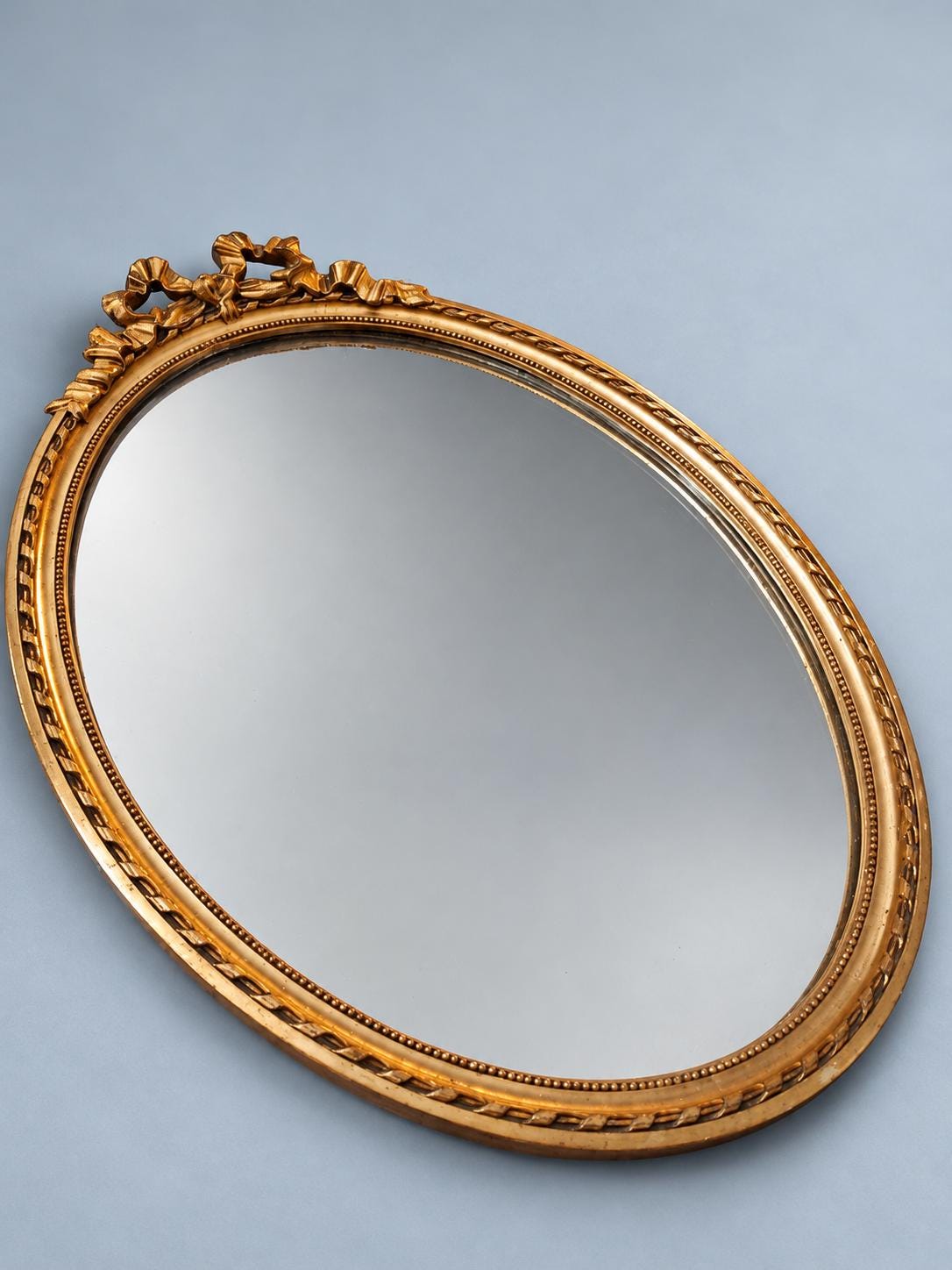 Vintage Oval Louis XVI Style Wall Mirror with Ribbon Bow Crest, Attributed 1960s, Gold-Tone Beaded Frame, 47 cm