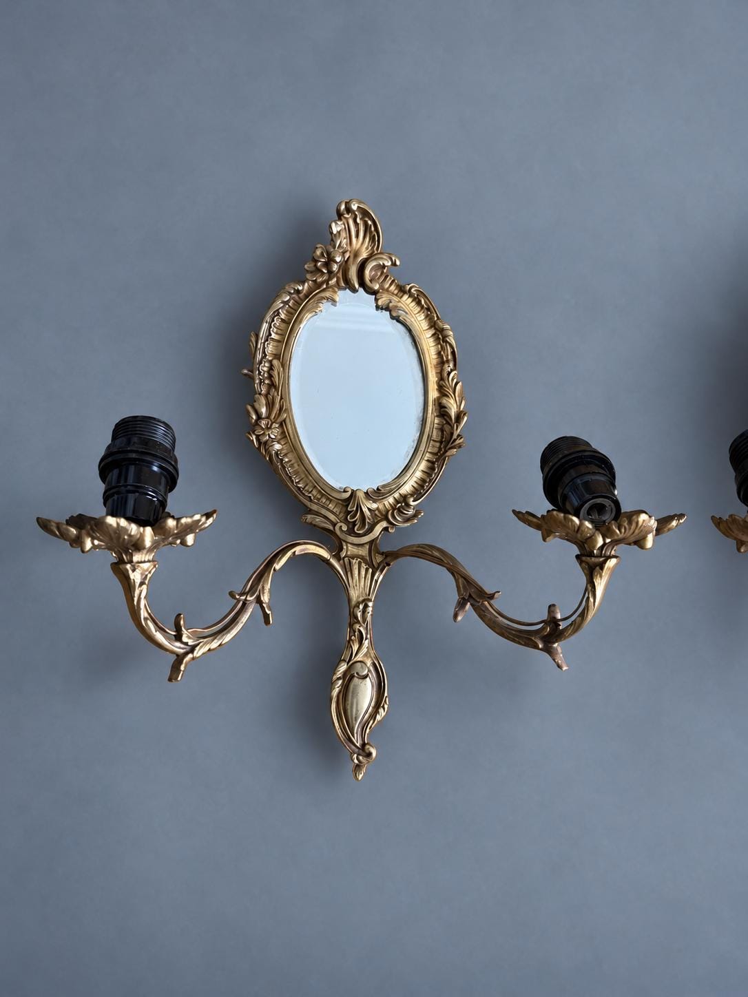 Vintage Pair of Rocaille Style Mirror Wall Sconces, Oval Bevelled Mirrors in Gilt Metal Frames, Leafy Two-Light Arms