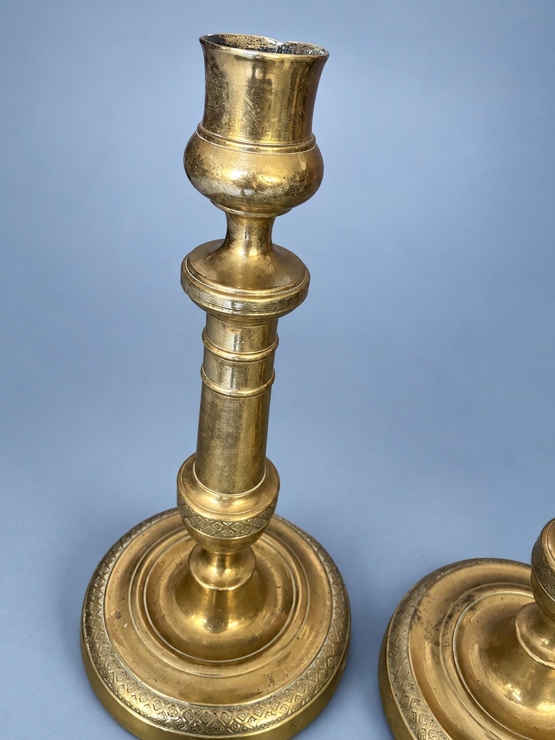 Antique Pair of Empire Style Brass-Tone Candlesticks with Ringed Shafts and Chased Diaper Bands, 19th Century