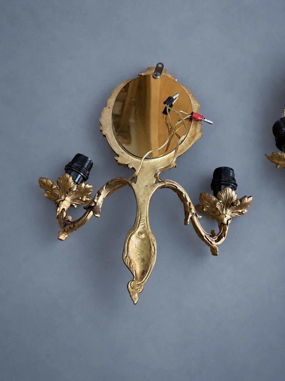 Vintage Pair of Rocaille Style Mirror Wall Sconces, Oval Bevelled Mirrors in Gilt Metal Frames, Leafy Two-Light Arms
