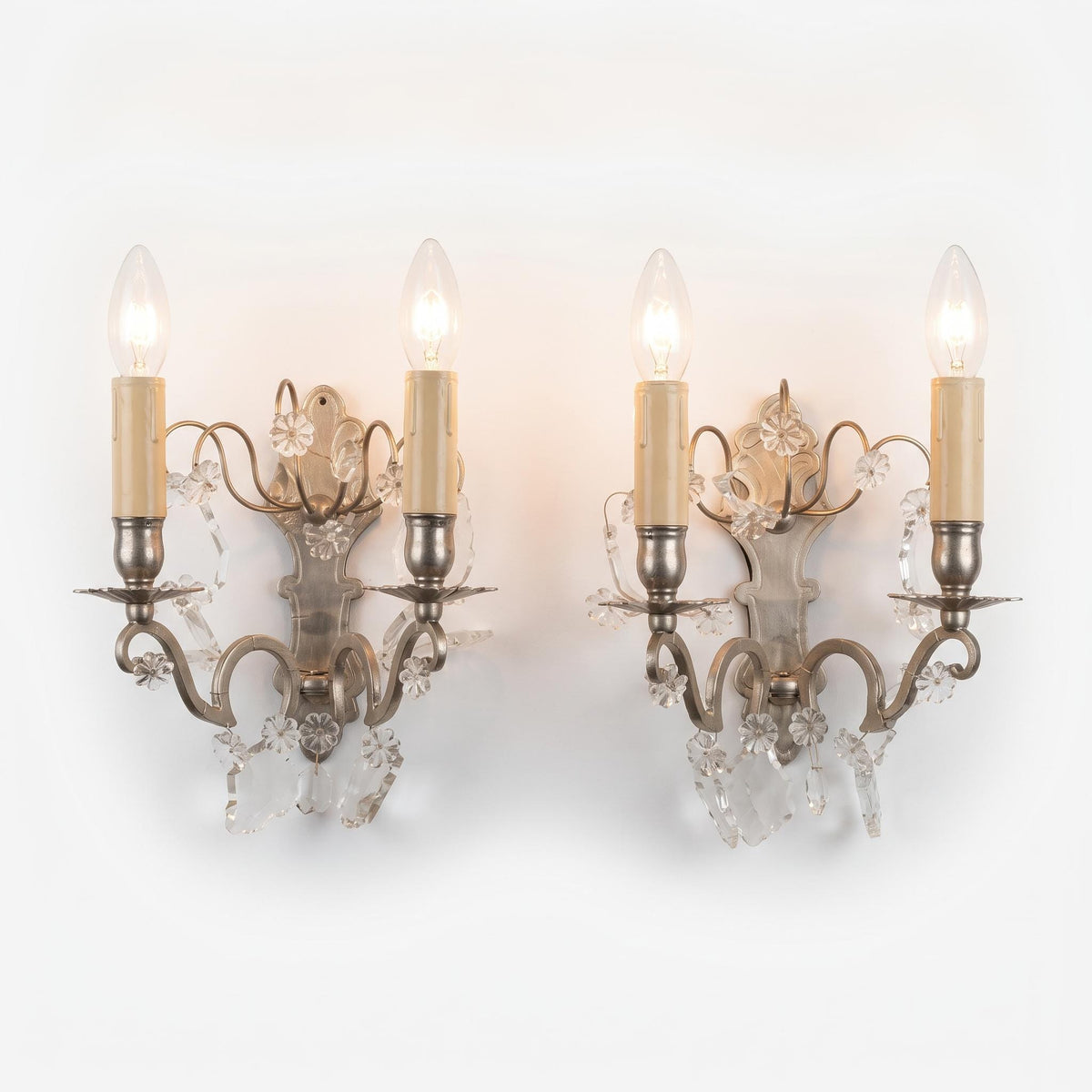 Pair of Vintage Louis XV Style Nickel-Plated Brass Wall Sconces with Crystal Drops, Two-Arm Silver-Tone Lights, Circa 1920s–1940s