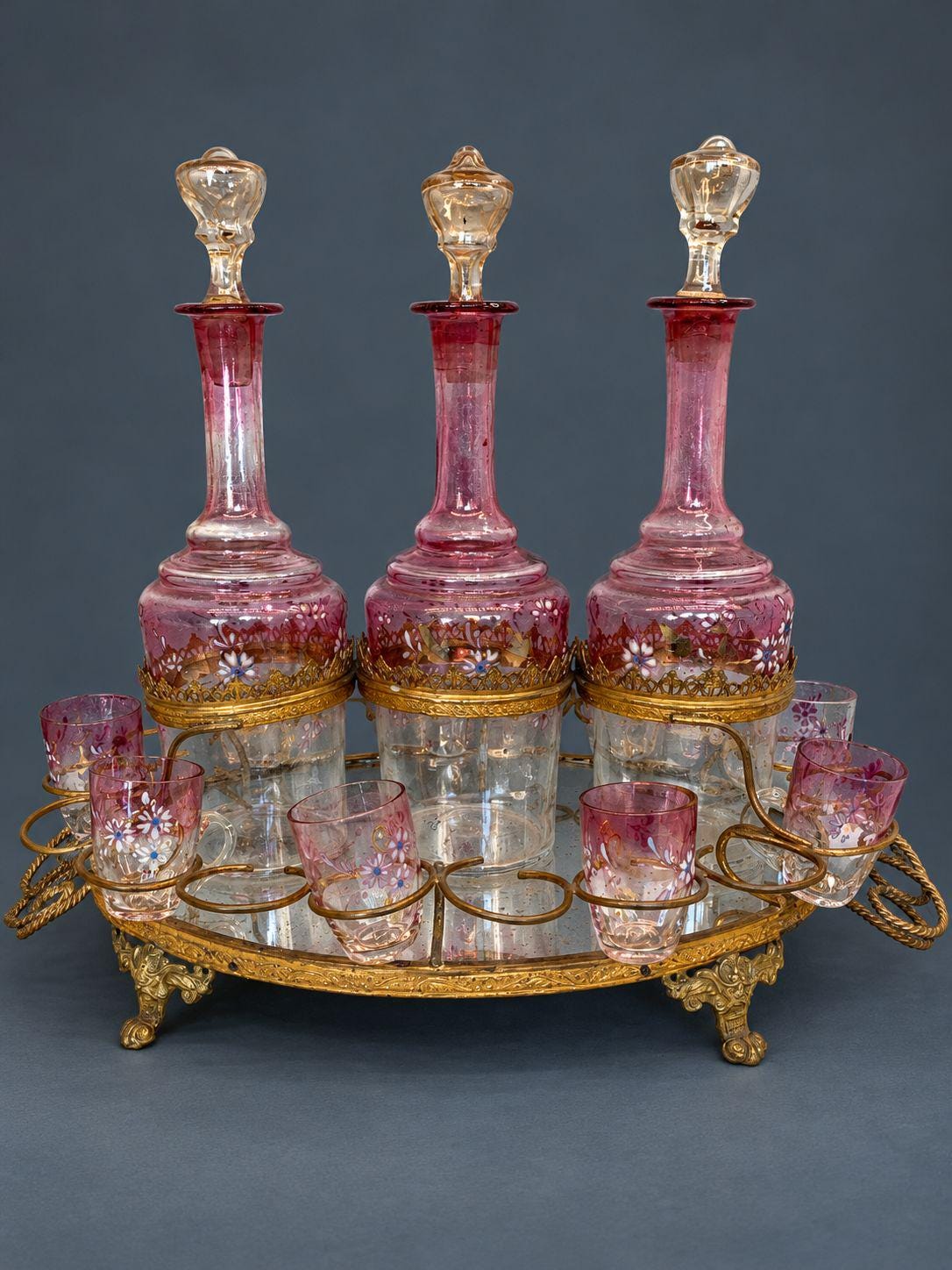 Antique Napoleon III Liqueur Set, Two Cranberry Enameled Glass Decanters and Cordial Glasses on Gilt Brass Mirrored Tray Stand